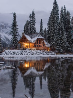 Snowy lodge at the edge of a forest and lake